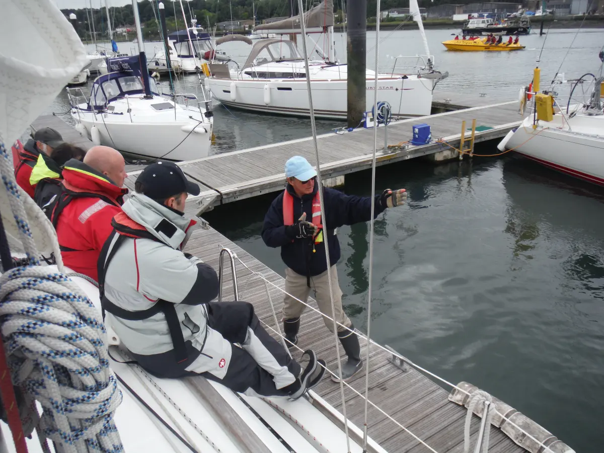 Yacht manoeuvring discussion in a marina with instructor guidance