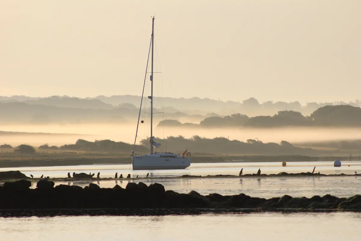 Yacht at anchor in Newtown Creek one morning in August sailing on the Solent with yacht anchored early morning in scenic waters