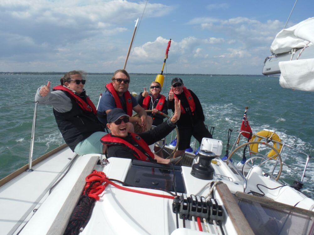 A happy crew with all their FAQs about Sailing Courses answered