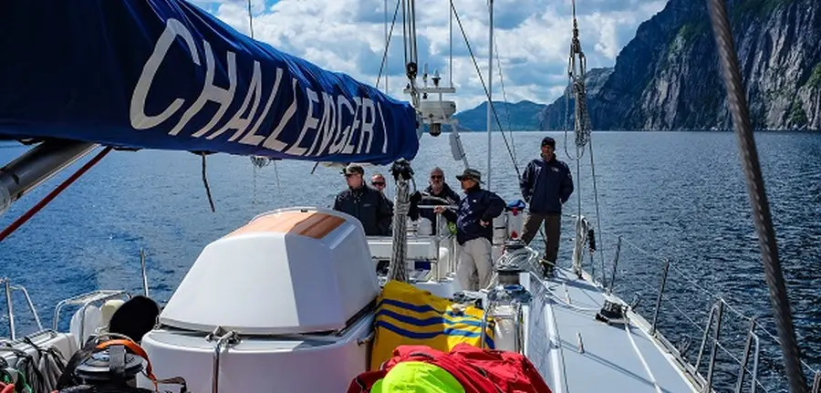 Sailing yacht cruising in Norway fjord during mile building trip