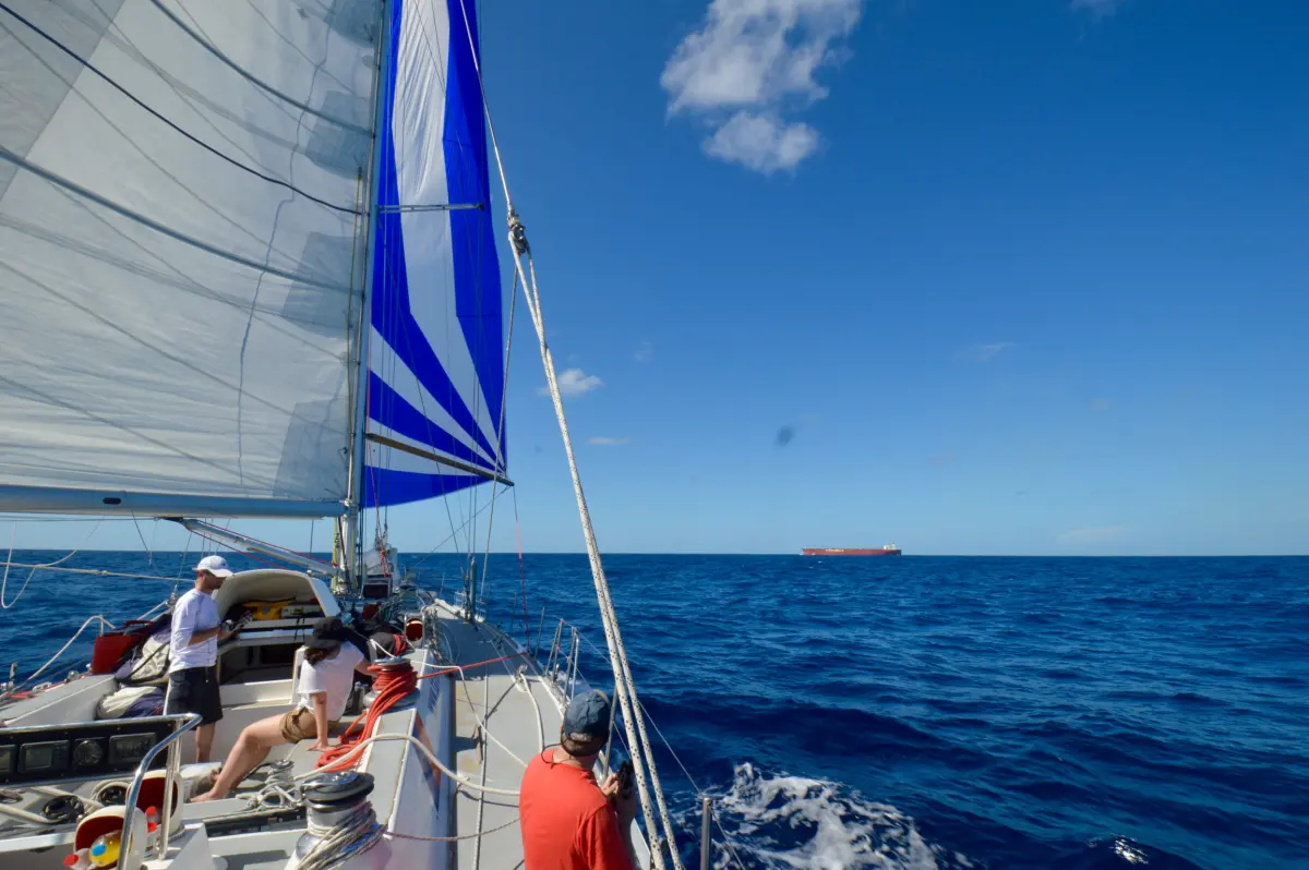 ARC yacht sailing downwind in Atlantic trade winds with spinnaker set