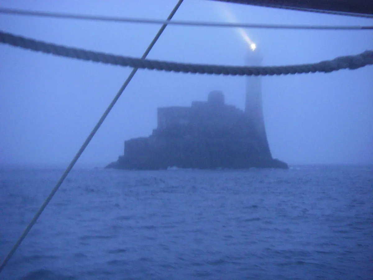RORC Round Britain & Ireland yacht passing the Fastnet Rock in fairly unpleasant conditions