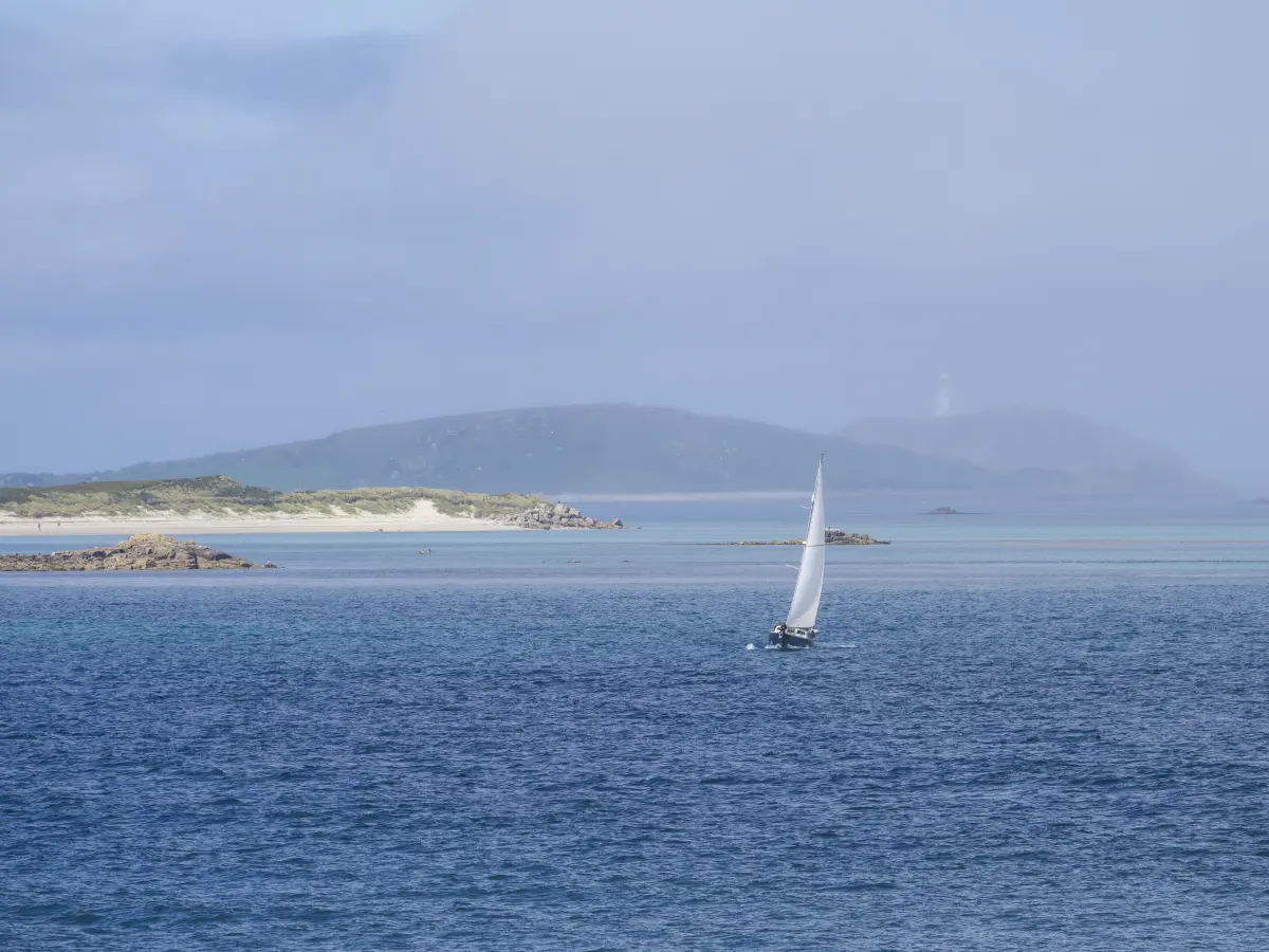 Sailing yacht approaching the Isles of Scilly from Cornwall
