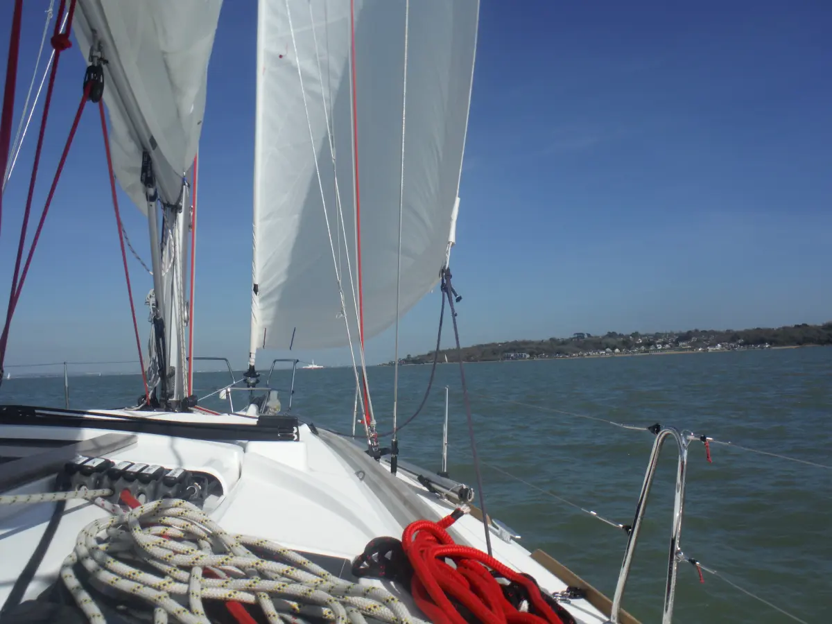 Yacht with sails out sailing along the Dorset coast. Worth it to stay in the UK this summer.