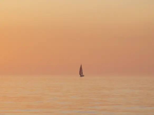 Offshore sailing yacht at sunset after completing navigation training